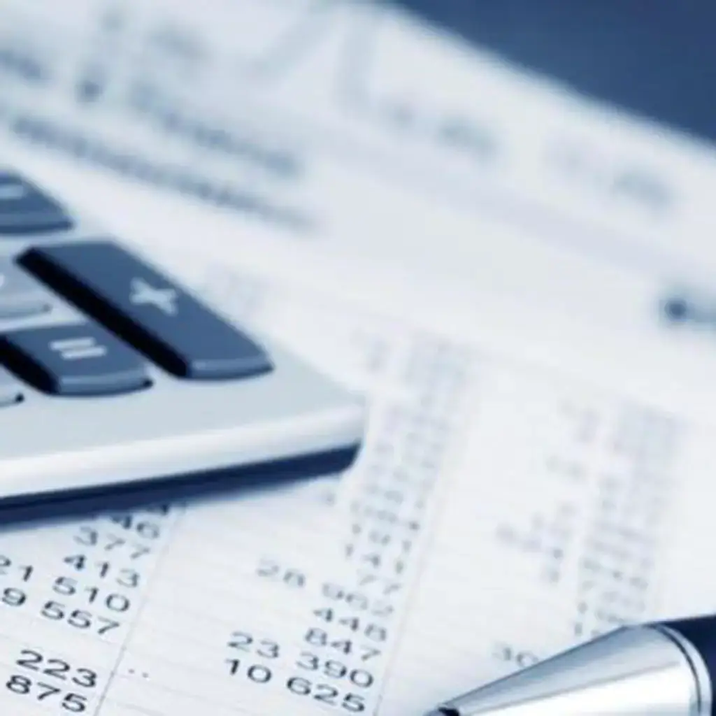 Calculatrice et documents fiscaux sur une table, illustrant les avantages fiscaux du leasing pour les entreprises en Suisse, proposés par Ecofina.